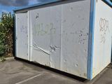 a white box with graffiti on it sitting in a parking lot