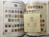 an open book with stamps on it on a table