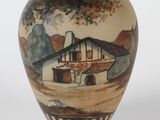 un vase avec une peinture sur une surface blanche