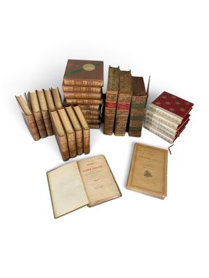 several old books are stacked on top of each other on a white surface