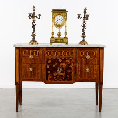 une table sur laquelle se trouvent une horloge et deux bougies