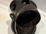 a black vase that is sitting on a white table