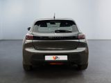 the rear end of a grey car in a room with a white wall