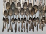 a lot of silver spoons and forks on the table