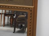 a mirror on the wall reflecting a table and chairs