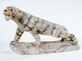 statue en marbre représentant un tigre posé sur un rocher, sur fond blanc