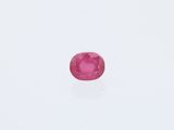un gros plan d'un saphir rose posé sur une surface blanche