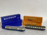 trois wagons de train miniature placés les uns à côté des autres sur une surface blanche