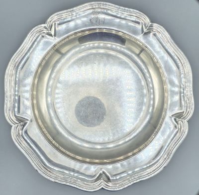 an antique silver plate on a table with a black background