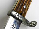 a close up of a knife on a white surface