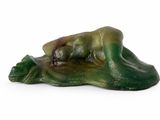 a figurine of a frog that is laying down on the ground