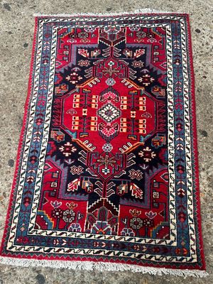 un tapis rouge et bleu posé sur un sol en béton
