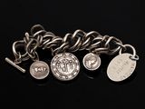 un gros plan sur un bracelet à maillons orné de pièces et d'un pendentif en forme de pièce