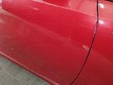 a close up of a red car with a sticker on it