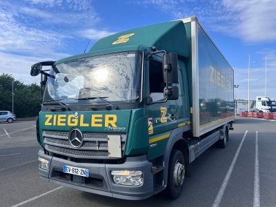 un camion vert garé sur un parking