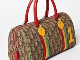 brown and red duffel bag with red handles on white background