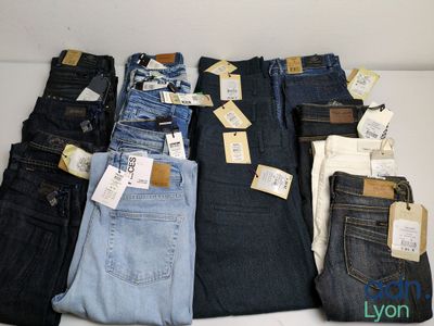 several pairs of men ' s jeans sitting on a table with price tags on them