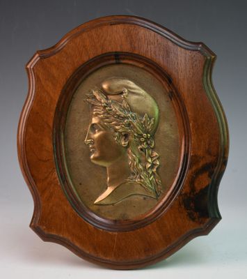 une photo d'une plaque en bronze représentant une femme coiffée d'une couronne