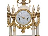 a white and gold clock sitting on top of a table