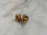 pair of gold plated earrings on a marble counter top