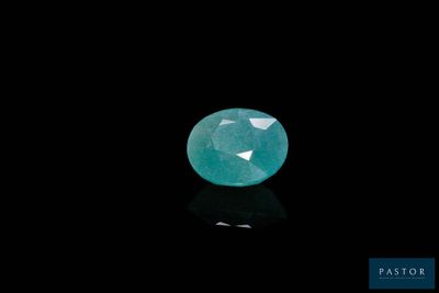 an oval faceted emerald gems on a black background