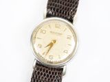 une image représentant une montre avec un bracelet en cuir marron sur un fond blanc