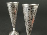 deux vases en argent posés l'un à côté de l'autre sur une table