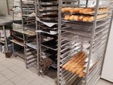 de nombreux plateaux de pain posés sur une étagère dans la cuisine