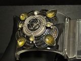 silver and gold cuff bracelet with yellow stones on a black leather case