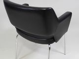a black leather lounge chair with chrome legs on a white background