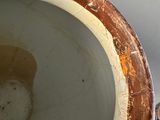 a brown and white vase sitting on a table