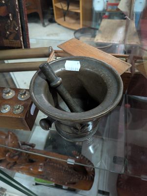 a glass display case with a mortar and other items on it