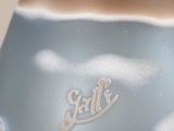 a blue vase with a white base with a name on it