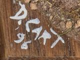 a close up of a piece of wood with writing on it