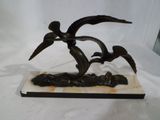une statue représentant un oiseau perché sur un socle en marbre