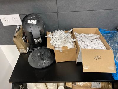 a black table topped with boxes of toilet paper and a coffee maker