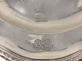 a silver plate with a silver lid on a white background