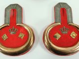 pair of red and gold medals with a crown on each of them