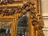 a gold framed mirror with flowers and leaves on it