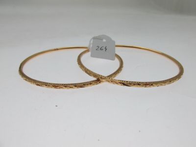 deux bracelets rigides en or ornés de motifs gravés