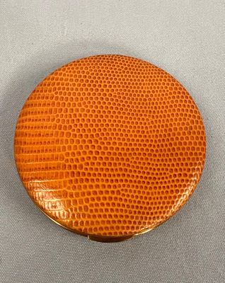 an image of a round orange purse sitting on top of a table