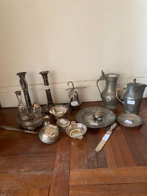 a lot of silver items on the floor next to a wall