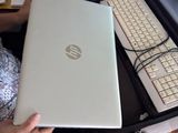 une femme assise à un bureau, devant un ordinateur portable et un clavier
