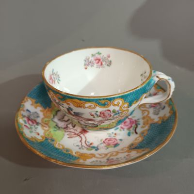a tea cup and saucer sitting on a table