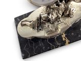 a silver clock sitting on top of a black marble block
