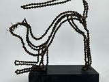 une photo d'une sculpture représentant un chien, réalisée à partir de chaînes