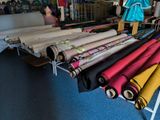 many rolls of fabric sitting on a table in a room