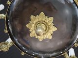 an image of a gold plate with a flower on it