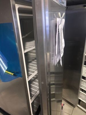 a large stainless steel refrigerator in a kitchen with a blue towel hanging from the door