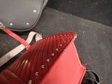 a red purse and a black purse on the floor